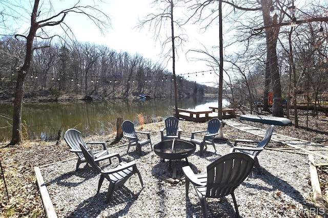 view of patio featuring an outdoor fire pit and a water view
