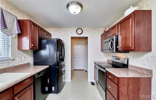 kitchen with black appliances, wallpapered walls, light countertops, baseboards, and a sink