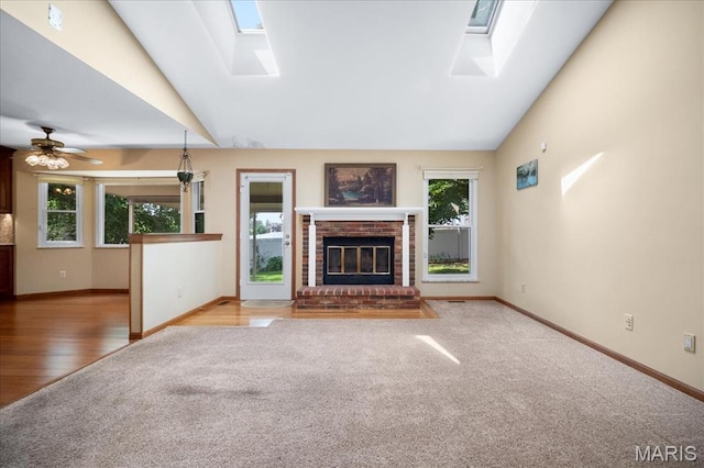 221 Greiner Ct, Ellisville, MO 63021 - unfurnished living room featuring a skylight, carpet, lofted ceiling, a brick fireplace, and ceiling fan