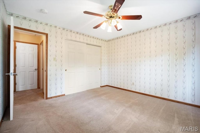 221 Greiner Ct, Ellisville, MO 63021 - unfurnished bedroom featuring wallpapered walls, carpet floors, a closet, and a ceiling fan