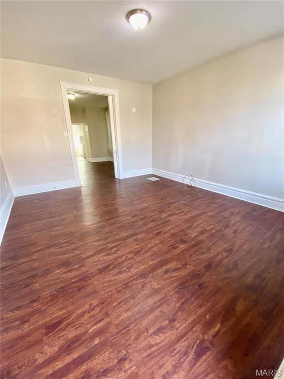unfurnished room with dark wood-style floors and baseboards