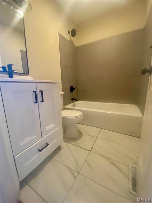 bathroom featuring vanity, shower / bath combination, and toilet