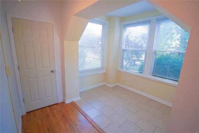 bonus room featuring healthy amount of natural light, baseboards, and light tile patterned floors