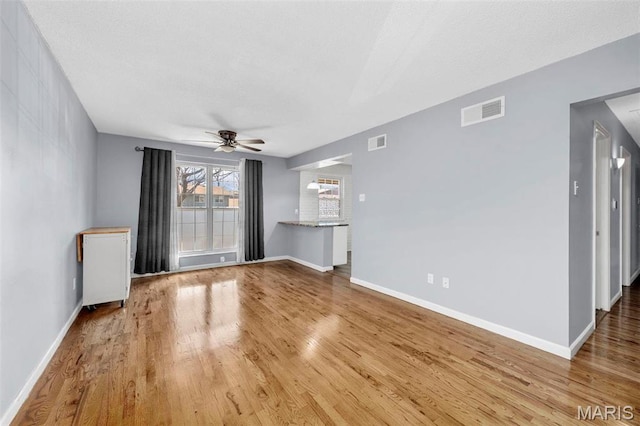 8724 Santa Bella Dr Unit G, Hazelwood, MO 63042 - unfurnished living room with wood finished floors, ceiling fan, and baseboards