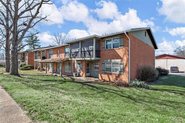 8724 Santa Bella Dr Unit G, Hazelwood, MO 63042 - back of property with brick siding, a lawn, and a sunroom