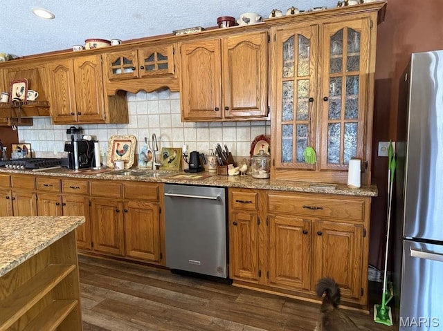 27409 Missouri Dr, Lebanon, MO 65536 - kitchen featuring stainless steel appliances, brown cabinetry, decorative backsplash, and dark wood-style floors