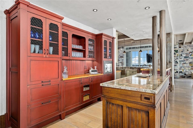 150 Carondelet Unit 2901, Saint Louis, MO 63105 - kitchen featuring reddish brown cabinets, light wood-style floors, light stone countertops, and recessed lighting
