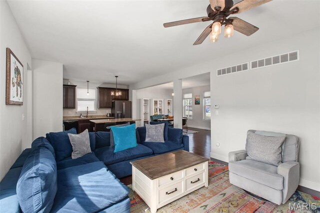 3208 Henrietta St, Saint Louis, MO 63104 - living room with baseboards, ceiling fan, light wood-style floors, and a chandelier
