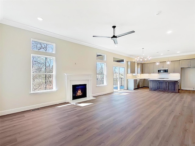 220 Great Bear Pass, Foristell, MO 63348 - unfurnished living room featuring a chandelier, crown molding, a fireplace with flush hearth, wood finished floors, and ceiling fan