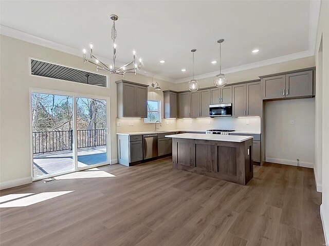 220 Great Bear Pass, Foristell, MO 63348 - kitchen featuring appliances with stainless steel finishes, a sink, a chandelier, light countertops, and a center island