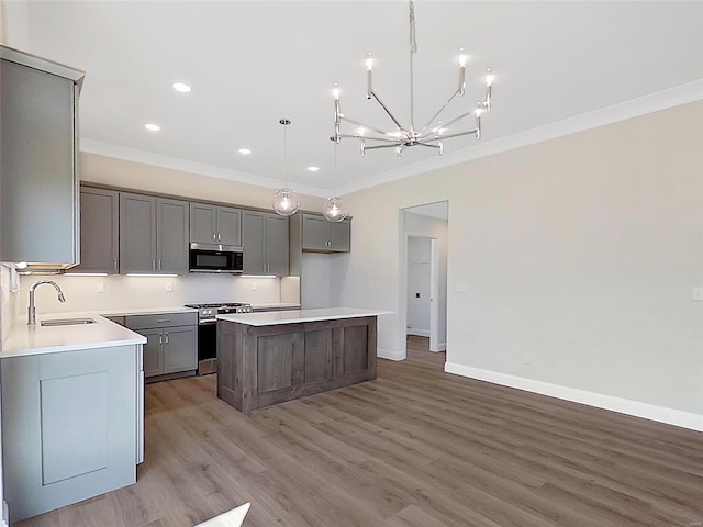 220 Great Bear Pass, Foristell, MO 63348 - kitchen featuring appliances with stainless steel finishes, ornamental molding, a sink, gray cabinetry, and a kitchen island