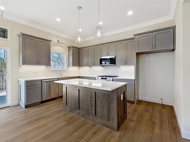 220 Great Bear Pass, Foristell, MO 63348 - kitchen with stainless steel appliances, a sink, backsplash, a kitchen island, and light wood finished floors