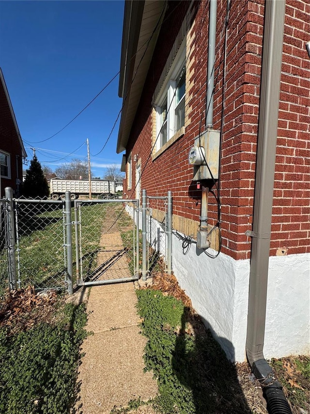 1522 E 5th St, Washington, MO 63090 - view of property exterior featuring brick siding, fence, and a gate