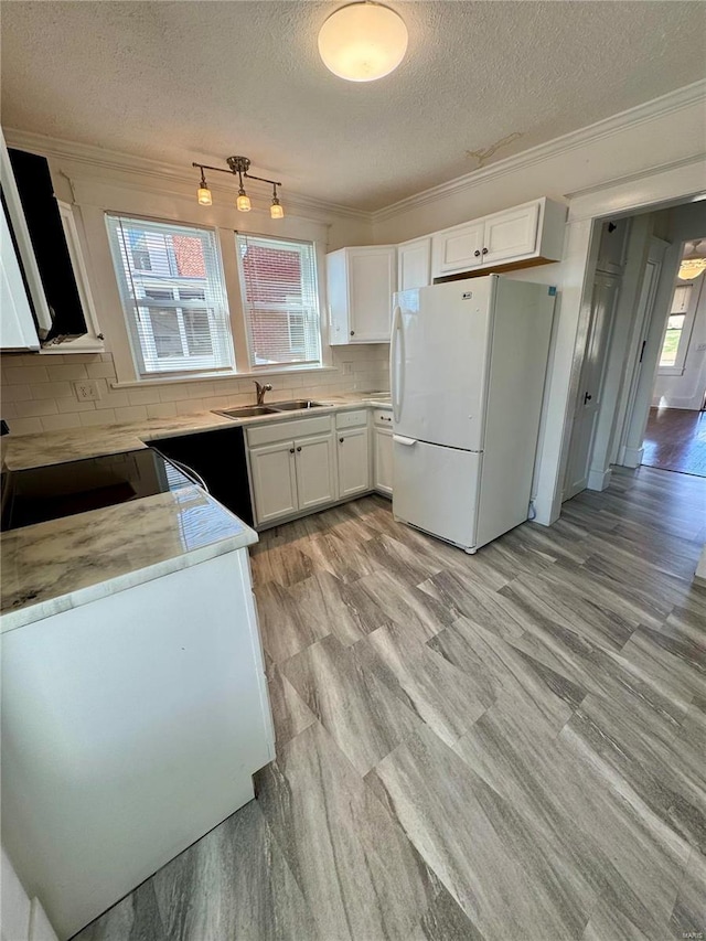 1522 E 5th St, Washington, MO 63090 - kitchen featuring freestanding refrigerator, ornamental molding, a textured ceiling, tasteful backsplash, and white cabinetry