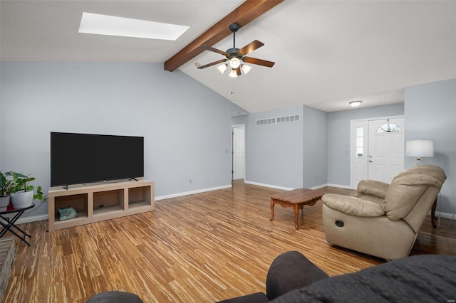 living area featuring wood finished floors, baseboards, ceiling fan, and a skylight