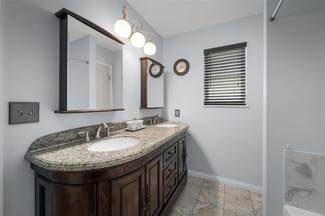 bathroom with baseboards and double vanity