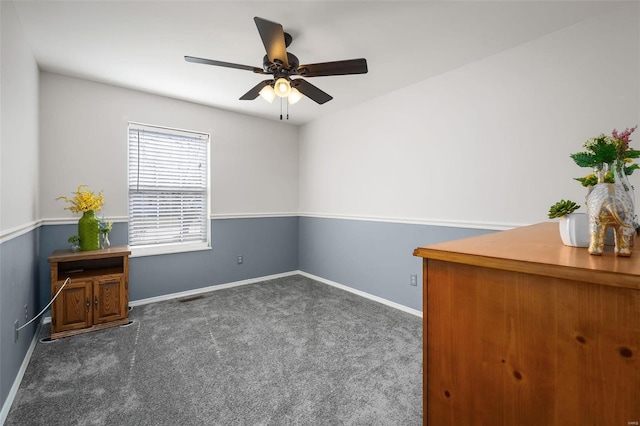carpeted spare room with ceiling fan and baseboards