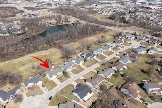 aerial view of property and surrounding area featuring nearby suburban area and a large body of water