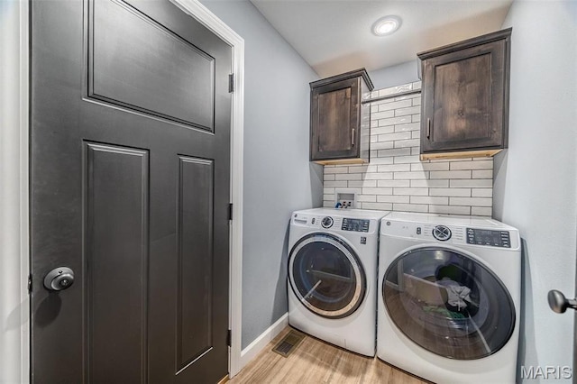 117 Alice Dr, Waynesville, MO 65583 - clothes washing area featuring washer and dryer, cabinet space, light wood-style floors, and baseboards