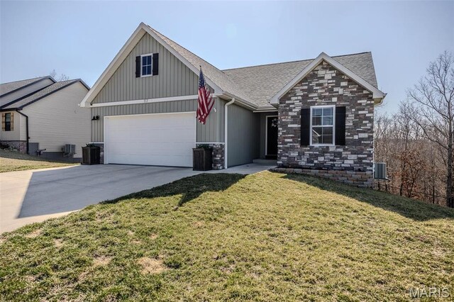 117 Alice Dr, Waynesville, MO 65583 - view of front facade with board and batten siding, central AC, concrete driveway, roof with shingles, and a front yard