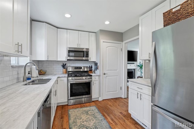 927 Gay Ave, Saint Louis, MO 63130 - kitchen with stainless steel appliances, a sink, white cabinets, and recessed lighting
