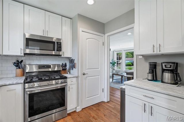 927 Gay Ave, Saint Louis, MO 63130 - kitchen with stainless steel appliances, light wood-type flooring, white cabinetry, and recessed lighting