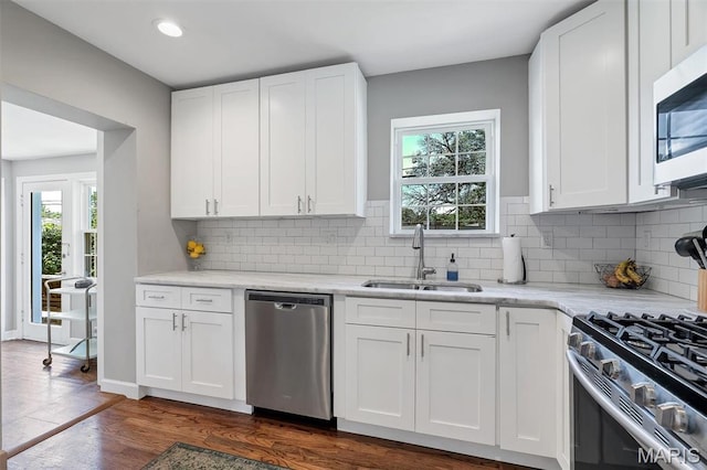 927 Gay Ave, Saint Louis, MO 63130 - kitchen featuring stainless steel appliances, a sink, white cabinetry, dark wood finished floors, and decorative backsplash
