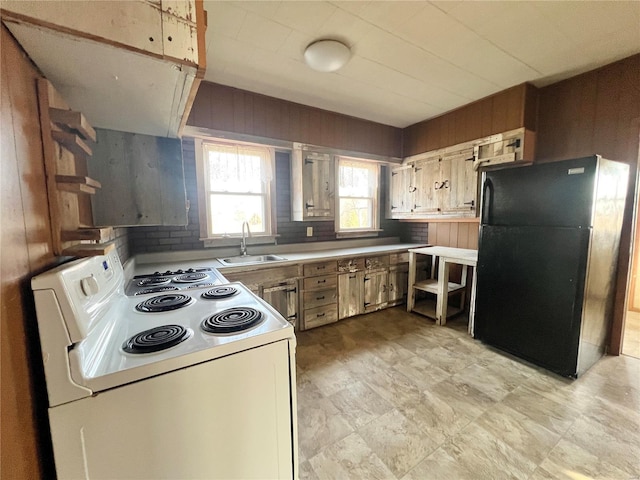 601 S Elm St, Center, MO 63436 - kitchen with electric stove, freestanding refrigerator, a sink, wood walls, and light countertops
