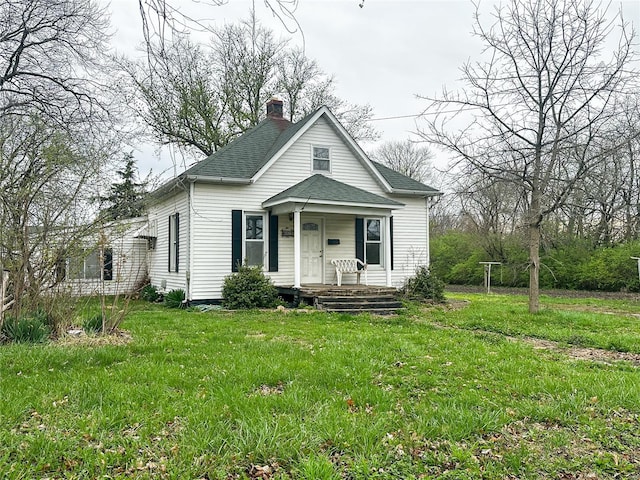 bungalow featuring a porch, a chimney, roof with shingles, and a front yard