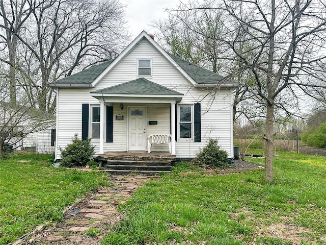 view of front of home featuring a shingled roof, a front lawn, and a porch