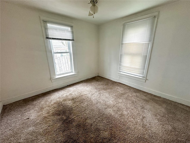 spare room featuring carpet floors, baseboards, and a ceiling fan