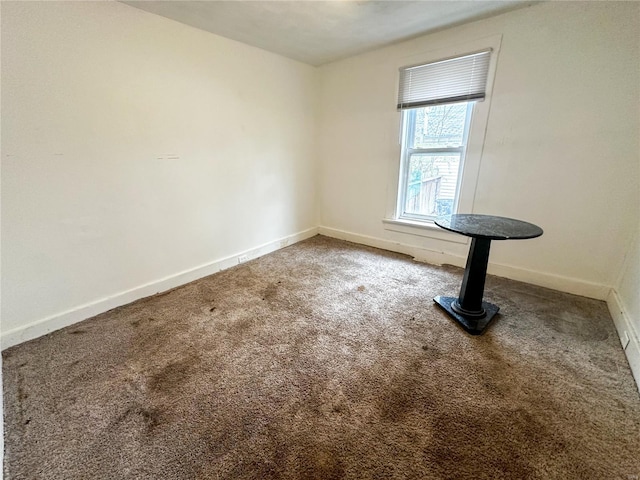 empty room featuring carpet floors and baseboards
