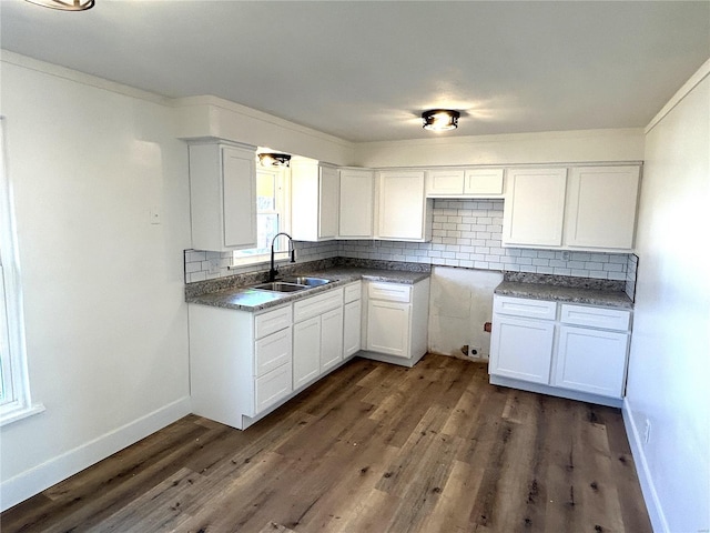 kitchen with a sink, dark wood finished floors, decorative backsplash, and white cabinetry
