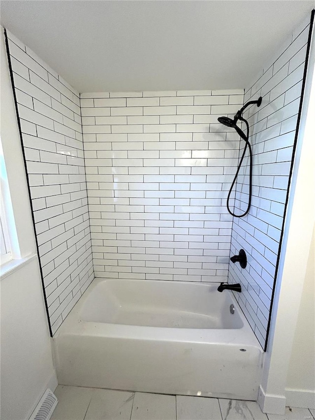 full bathroom with baseboards, marble finish floors, and shower / washtub combination