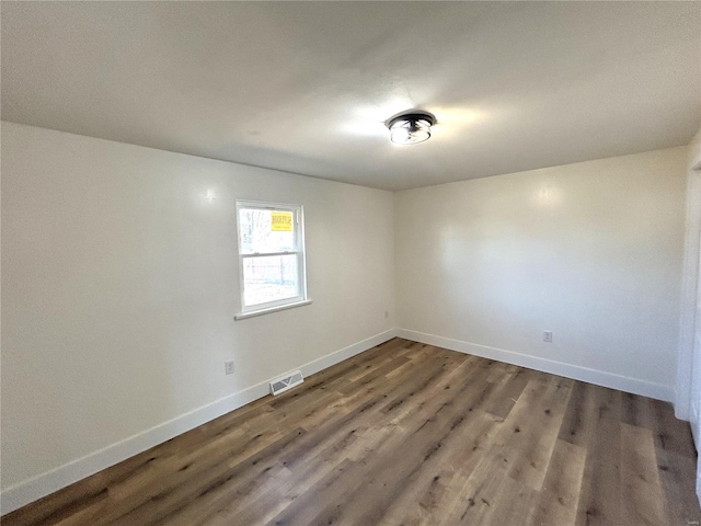 unfurnished room with baseboards and wood finished floors