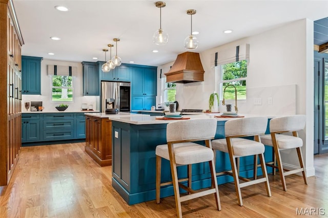 502 Briar Ridge Ln, Saint Louis, MO 63131 - kitchen featuring stainless steel fridge, blue cabinetry, premium range hood, a breakfast bar, and recessed lighting
