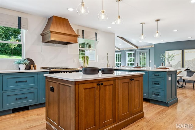 502 Briar Ridge Ln, Saint Louis, MO 63131 - kitchen with custom range hood, light wood finished floors, a center island, light countertops, and recessed lighting