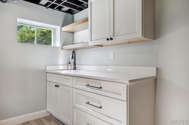 502 Briar Ridge Ln, Saint Louis, MO 63131 - kitchen with a sink, open shelves, light countertops, light wood finished floors, and white cabinetry