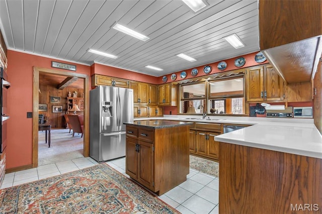 167 Red Fox Ln, Cape Girardeau, MO 63701 - kitchen featuring appliances with stainless steel finishes, light tile patterned floors, brown cabinets, and a center island