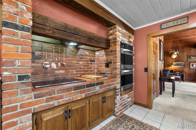 167 Red Fox Ln, Cape Girardeau, MO 63701 - kitchen with stainless steel double oven, light tile patterned floors, ornamental molding, brown cabinetry, and light colored carpet