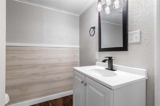 1005 Tyler St, Park Hills, MO 63601 - bathroom with a textured wall, vanity, ornamental molding, toilet, and wood finished floors