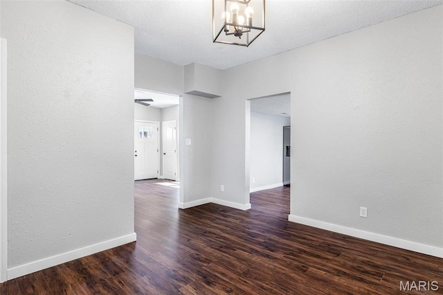 1005 Tyler St, Park Hills, MO 63601 - spare room featuring a chandelier, dark wood-type flooring, baseboards, and a textured wall