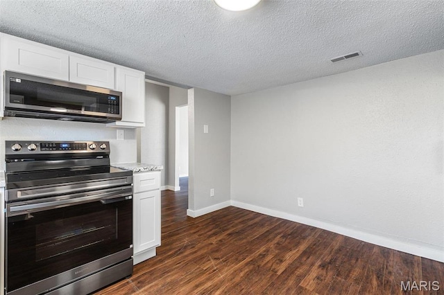 1005 Tyler St, Park Hills, MO 63601 - kitchen featuring stainless steel appliances, baseboards, dark wood-type flooring, white cabinetry, and a textured ceiling