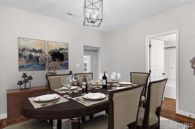 1005 Tyler St, Park Hills, MO 63601 - dining space with wood finished floors, a chandelier, baseboards, and a textured ceiling