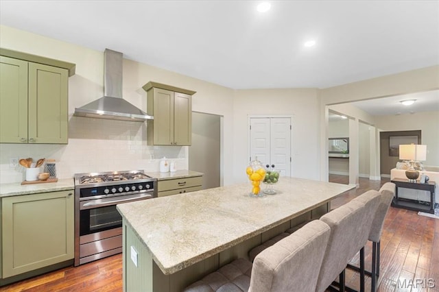115 Place De Yeager, Lake St Louis, MO 63367 - kitchen with gas stove, green cabinets, wall chimney range hood, dark wood-style flooring, and decorative backsplash