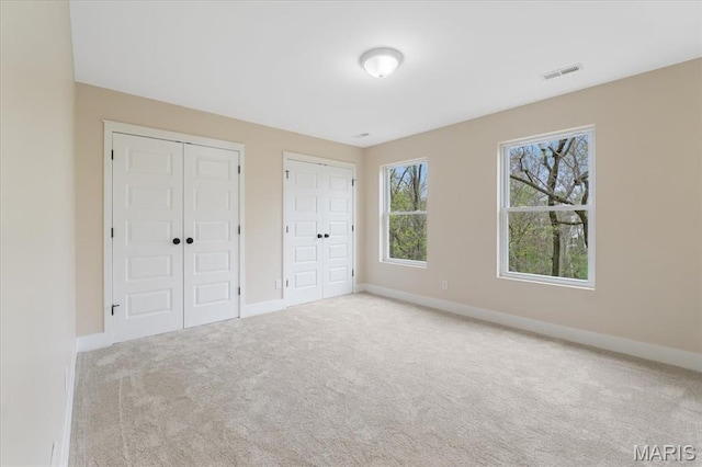 115 Place De Yeager, Lake St Louis, MO 63367 - unfurnished bedroom with two closets, carpet, and baseboards