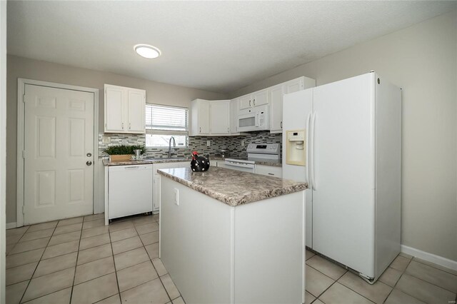 133 Lithia Ave, Saint Louis, MO 63119 - kitchen with white appliances, decorative backsplash, white cabinets, a center island, and light tile patterned floors