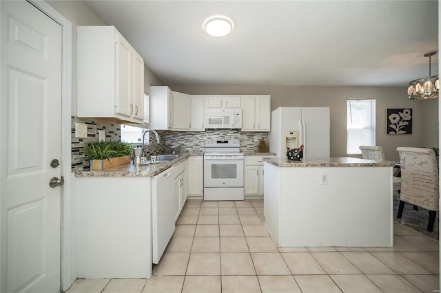 133 Lithia Ave, Saint Louis, MO 63119 - kitchen with white appliances, a sink, a kitchen island, tasteful backsplash, and white cabinets