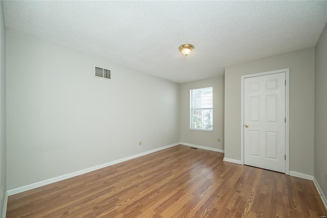 133 Lithia Ave, Saint Louis, MO 63119 - empty room featuring wood finished floors, baseboards, and a textured ceiling