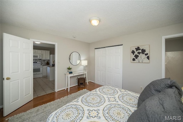 133 Lithia Ave, Saint Louis, MO 63119 - bedroom with wood finished floors, a closet, ensuite bathroom, and a textured ceiling